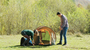 美丽的妻子帮助丈夫搭建露营帐篷30秒视频