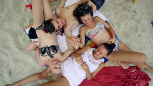 四位十几岁朋友躺在沙滩上双手握着的双手9秒视频