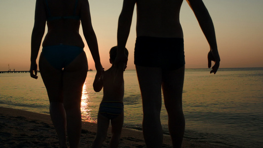 日落时父母亲和子女在海中沐浴视频