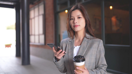 咖啡馆前的职场女生在玩手机喝咖啡视频