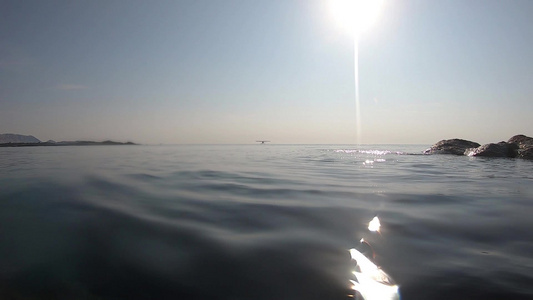 在早晨的逆光中在海平面上的水面上拍摄反射和地平线上视频