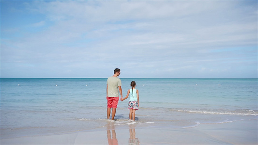 父亲和小女孩的家庭在海滩上玩得开心视频