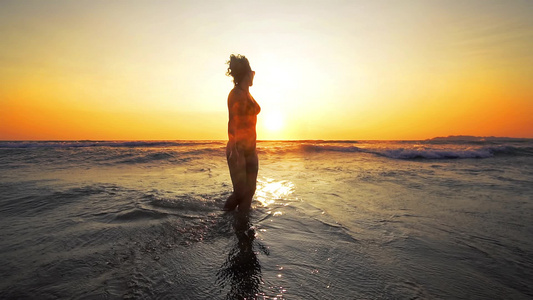 海滩日落时性感女人的剪影性感的身体完美的身材电影镜头视频