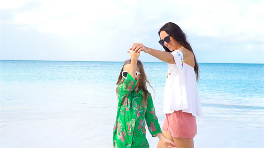 女孩和年轻妈妈在沙滩上一起玩得很开心视频