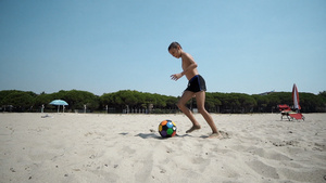 沙滩上的小男孩玩足球30秒视频