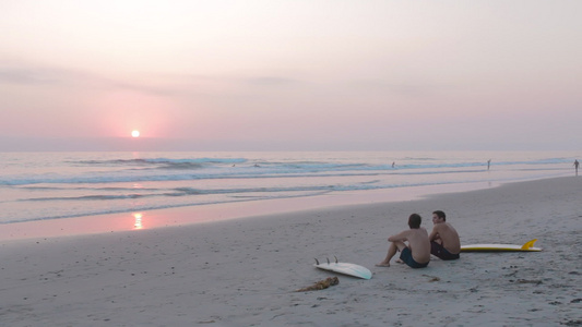 日落时坐在沙滩上视频