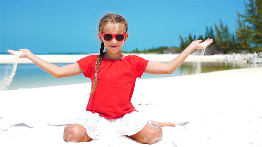 小女孩在热带沙滩玩美丽的白沙子慢动作慢动作视频