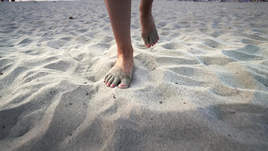 妇女赤脚在沙滩上走着沙子被固定的子弹击中视频