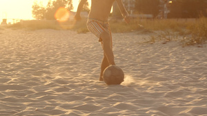 一个男孩在沙滩上踢足球15秒视频