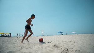 男孩在海滩踢足球慢动作29秒视频