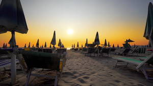 海边度假胜地的空沙滩有折叠的太阳休息员和在日落天幕12秒视频