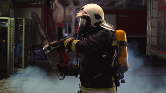 身穿全套设备氧气罩和电动液压切割工具烟雾和消防车的视频