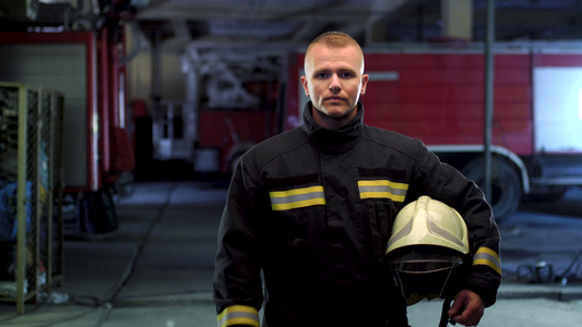 消防员身穿制服戴上黄色防护头盔视频人像消防车在背景视频