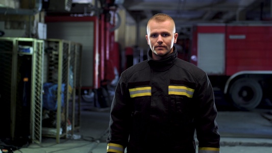 消防员身穿制服的视频肖像背景中的消防车摄像机向左移动视频