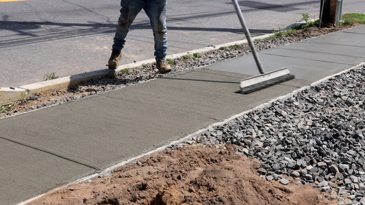 工人完成工作在侧边行驶期间新水泥上漂滑的混凝土表面视频