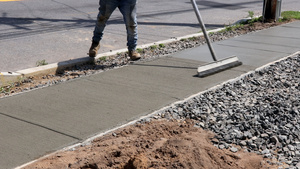 工人完成工作在侧边行驶期间新水泥上漂滑的混凝土表面15秒视频