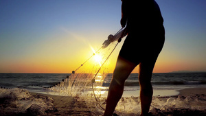 海岸沿岸捕鱼渔民在海边日落时用手拉网7秒视频