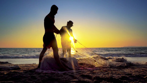 日落时传统渔民在海洋海岸拉网捕鱼的休光轮27秒视频