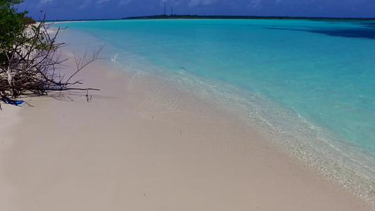 阳光明媚的海滨海滩风景在海浪附近以白沙为背景的清澈视频