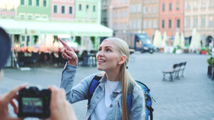 在市集广场上拍摄女游客照片的画面城市市场广场一角19秒视频