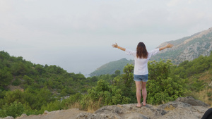 女人站在山边伸出双手15秒视频