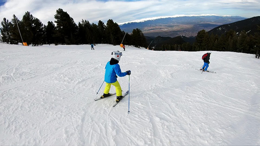 带头盔的小男孩移动滑雪坡慢动作视频