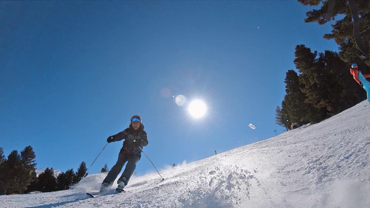 在阳光明媚的日子里在斜坡上滑雪慢动作视频
