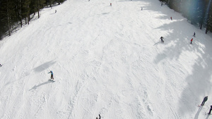 阳光明日滑雪山坡上滑雪者和滑雪运动员的空中观察18秒视频