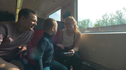 父母和子女乘火车及使用手机旅行的视频