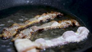 用大量油在平底锅中煎炸的香脆培根片的特写镜头猪肉培根8秒视频