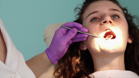 在牙医办公室进行牙齿检查牙医在牙医椅上检查女孩的牙齿视频