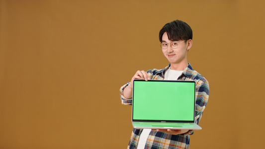 男青年展示笔记本电脑绿幕视频