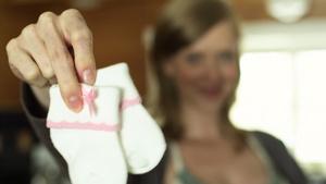 孕妇拿起婴儿袜对着镜头大笑18秒视频