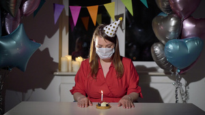 单独庆祝其生日的年轻妇女戴着保护性医疗面具的女童18秒视频