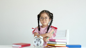 小女孩面对着时钟和书本站立并发怒12秒视频
