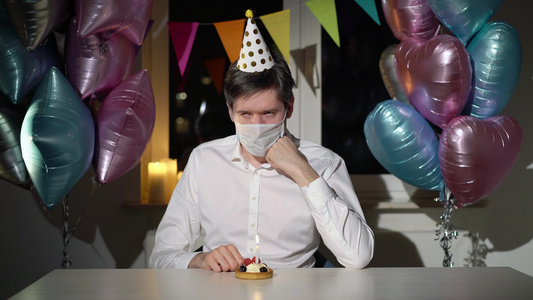 独自庆祝生日的年轻男子戴着保护性医疗面具的男性视频