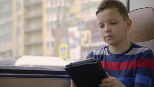 利用计算机平板电脑上的社交网络对一名青年男孩用公共汽车视频