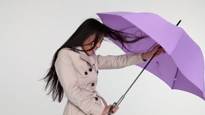 风中撑伞的年轻女子13秒视频