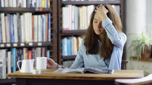 年轻女孩喝着咖啡阅读杂志视频