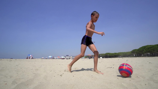 男孩在海滩上享受踢踢球的乐趣电影制片人Standicam视频