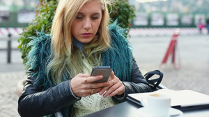 女子坐在户外使用智能手机回复消息8秒视频