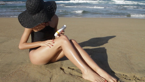 在海滩上涂防晒霜的年轻女子7秒视频