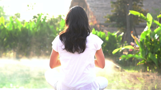 在阳光下温泉池旁边做瑜伽的女性视频