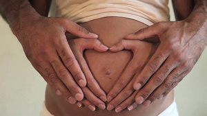 男人的手在她怀孕的肚子上加入女人的心形12秒视频