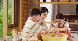 年轻陶艺女教师陪小朋友们做陶罐11秒视频