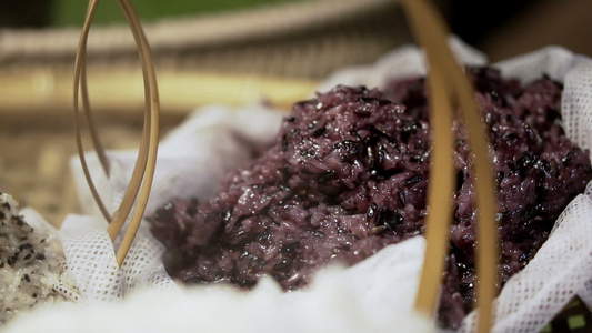 在泰国市场竹篮中蒸炒黑紫粘黏的稻谷视频