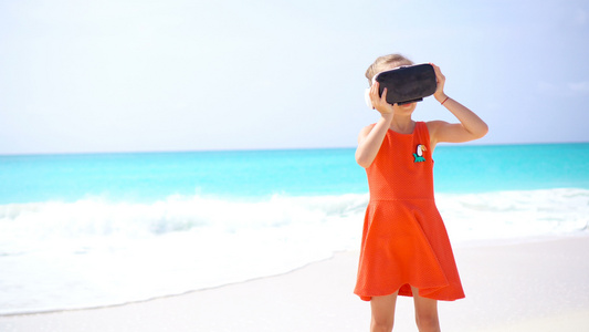 可爱小女孩在海滩上使用Vr虚拟现实护目镜视频