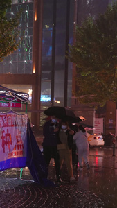 素材升格拍摄慢镜头公益医疗城市雨天夜晚接种完疫苗的情侣慢动作视频