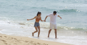 8K情侣手牵手在沙滩上开心散步13秒视频