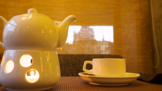 烧蜡烛和茶杯中的热茶在桌上的茶杯里视频